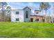 Modern farmhouse with white siding, a gray accent, black windows, and a lush green lawn on a sunny day at 140 Wesley Pl, Fayetteville, GA 30214