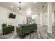 Open concept living room with light wood floors, a green sofa and chairs, and modern light fixtures at 140 Wesley Pl, Fayetteville, GA 30214