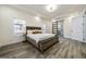 Spacious main bedroom with gray wood floors, windows, and a barn door to the ensuite bathroom at 140 Wesley Pl, Fayetteville, GA 30214