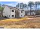 Expansive rear view of a two-story white farmhouse with a wood balcony and black trimmed windows at 140 Wesley Pl, Fayetteville, GA 30214