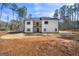 Rear exterior of two story white farmhouse with black trim windows and wood balcony on a sunny day at 140 Wesley Pl, Fayetteville, GA 30214