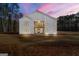 Exterior rear view showcasing its white siding, second story balcony and manicured lawn at twilight at 130 Wesley Pl, Fayetteville, GA 30214