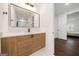 Bright bathroom with white marble floors, wood vanity and modern fixtures at 130 Wesley Pl, Fayetteville, GA 30214