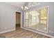 Bright dining room with wood floors, modern chandelier, and large window with natural light at 230 Hidden Brook Trl, Fayetteville, GA 30215