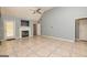 Open living room featuring a fireplace, tiled floors, high ceilings, and a ceiling fan at 230 Hidden Brook Trl, Fayetteville, GA 30215