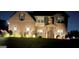 Brick two-story home with manicured front lawn landscaping, illuminated for nighttime appeal at 110 Broadwater Dr, Fayetteville, GA 30214