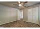 Bright bedroom with neutral carpet flooring, ceiling fan, and double door closet at 9689 Pintail Trl, Jonesboro, GA 30238