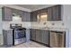 Stylish kitchen with updated stainless appliances, granite countertops, gray cabinets and laminate flooring at 9689 Pintail Trl, Jonesboro, GA 30238