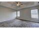 Spacious main bedroom with tray ceiling, ceiling fan, carpet, and windows at 9689 Pintail Trl, Jonesboro, GA 30238