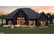 Modern farmhouse with a dark exterior, large windows, and a spacious covered patio for outdoor living at 0 Coastline Rd # 5, Fayetteville, GA 30214