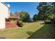 A backyard with a wooden deck, lawn, mature trees, and a fire pit, perfect for enjoying the outdoors at 3540 Owl Brow Ct, Cumming, GA 30028