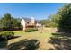 Spacious backyard with a fire pit, lawn, mature trees, and a wooden deck for outdoor living at 3540 Owl Brow Ct, Cumming, GA 30028