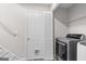 Spacious laundry room featuring white appliances, wire shelving, and a cat door at 3540 Owl Brow Ct, Cumming, GA 30028