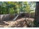 Backyard playground featuring a slide and swings surrounded by a wooden fence and shade trees at 3540 Owl Brow Ct, Cumming, GA 30028