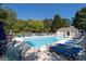 Community pool with ample lounge chairs and umbrellas, surrounded by a white fence at 3540 Owl Brow Ct, Cumming, GA 30028