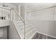 Bright interior shot showcasing a staircase with white railings and modern wood-look floors at 3540 Owl Brow Ct, Cumming, GA 30028
