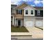 Townhome features brick accents, a two-car garage, and a blue front door at 8708 Lakeview Commons # 47, Jonesboro, GA 30238