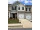New townhome featuring a brick front, attached garage, driveway, and lawn at 8726 Lakeview Commons # 50, Jonesboro, GA 30238