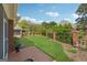 Well-maintained backyard featuring a lush lawn, defined garden beds, brick patio and a black iron fence at 1570 Woodberry Run Dr, Snellville, GA 30078
