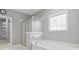 Elegant bathroom featuring a shower, tub, and an decorative glass window at 1570 Woodberry Run Dr, Snellville, GA 30078