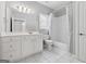 Bright bathroom features white tile floors, white cabinets and vanity, and a shower with patterned curtain at 1570 Woodberry Run Dr, Snellville, GA 30078