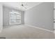 Spacious bedroom with neutral carpet, a large window with blinds, and gray walls at 1570 Woodberry Run Dr, Snellville, GA 30078