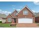 Beautiful two-story brick home featuring a brick driveway and an attached two-car garage at 1570 Woodberry Run Dr, Snellville, GA 30078