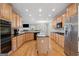 Well-lit kitchen with wood floors, island, stainless steel refrigerator, and built-in microwave above a cooktop at 1570 Woodberry Run Dr, Snellville, GA 30078