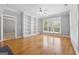 Spacious living room with hardwood floors, custom built-in bookshelves, and a large window at 1570 Woodberry Run Dr, Snellville, GA 30078