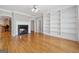 Elegant living room with hardwood floors, a fireplace, custom built-in bookshelves, and a ceiling fan at 1570 Woodberry Run Dr, Snellville, GA 30078
