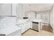 Bright kitchen boasts stainless steel appliances, white cabinets and a tile backsplash at 4875 Ben Hill Rd, College Park, GA 30349