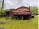 Multi-level deck at rear of brick home with lush lawn at 6501 River Run Rd, Riverdale, GA 30274