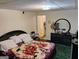 A cozy bedroom with floral bedding, dark furniture and personal touches at 6501 River Run Rd, Riverdale, GA 30274