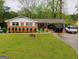 Charming brick home with a well-manicured lawn and covered parking at 6501 River Run Rd, Riverdale, GA 30274