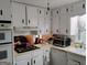 Bright kitchen featuring white cabinets and appliances at 6501 River Run Rd, Riverdale, GA 30274