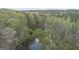 Aerial view reveals secluded home amidst mature trees and serene pond at 655 Sunset Dr, Locust Grove, GA 30248