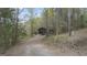 Long gravel driveway leading to a home surrounded by lush trees at 655 Sunset Dr, Locust Grove, GA 30248