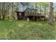 Rustic cabin-style home with wood siding and a raised deck nestled in a wooded setting at 655 Sunset Dr, Locust Grove, GA 30248
