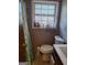 Cozy bathroom featuring a window with natural light, toilet, and sink at 1667 Park Pl, Lithia Springs, GA 30122