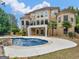 Beautiful backyard featuring a stunning pool, patio, spiral staircase, and lush greenery, perfect for outdoor enjoyment at 5297 Heron Bay Blvd, Locust Grove, GA 30248
