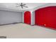 Spacious basement area with neutral carpet, red accent wall and overhead lighting at 5297 Heron Bay Blvd, Locust Grove, GA 30248