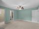 Bedroom with neutral carpet, ceiling fan, and access to ensuite bathroom and closet at 5297 Heron Bay Blvd, Locust Grove, GA 30248