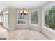 Bright breakfast nook with large windows, travertine floors, and a chandelier at 5297 Heron Bay Blvd, Locust Grove, GA 30248