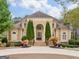 Elegant stucco home featuring a symmetrical facade, manicured landscaping, and a circular driveway at 5297 Heron Bay Blvd, Locust Grove, GA 30248