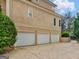 Three-car garage featuring white doors and ample parking space, adjacent to a landscaped area at 5297 Heron Bay Blvd, Locust Grove, GA 30248