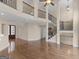 Open concept living space with a soaring ceiling, hardwood floors, and a staircase with iron railings at 5297 Heron Bay Blvd, Locust Grove, GA 30248