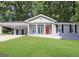 Charming single-story home featuring a covered carport, a red front door, and a well-maintained lawn at 2942 Elkhorn Ct, Decatur, GA 30034