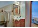 Well-lit bathroom with a wood vanity, decorative mirror, and access to other rooms at 3011 Broughton Rd, Newborn, GA 30056