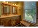 Bathroom featuring double vanity with tile backsplash and a sunlit window providing natural light at 3011 Broughton Rd, Newborn, GA 30056
