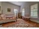 Cozy bedroom featuring a four-poster bed with colorful quilt, wood floors, and natural light at 3011 Broughton Rd, Newborn, GA 30056